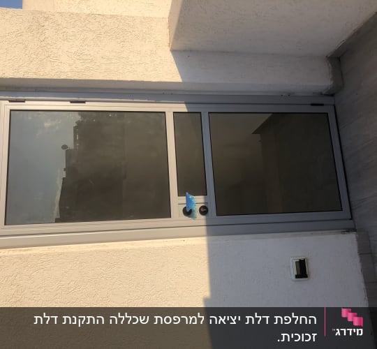 חלון אלומיניום עם מסגרת אפורה על קיר חיצוני